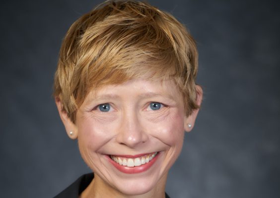 A professor smiles while posing for a headshot.