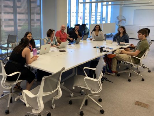 Group of people sitting around a table. 