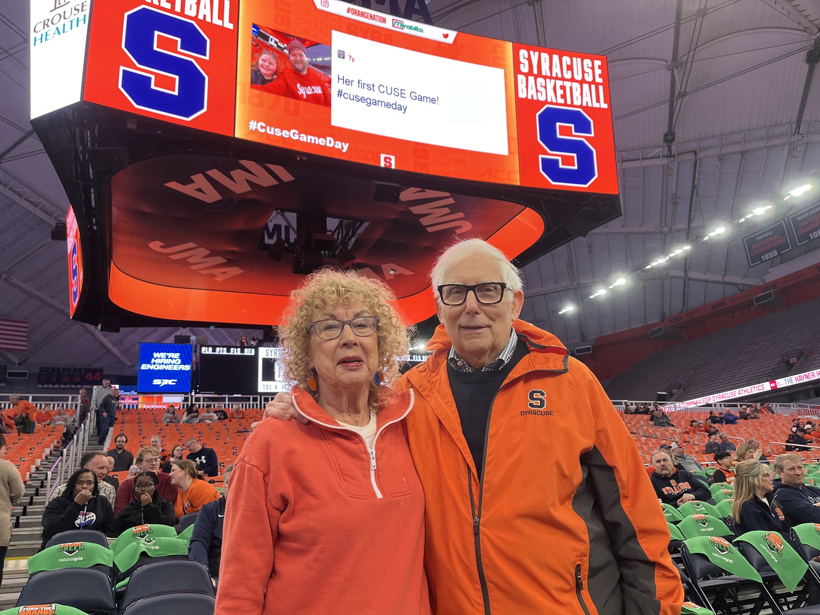 two people standing in seating at the JMA Wireless Dome