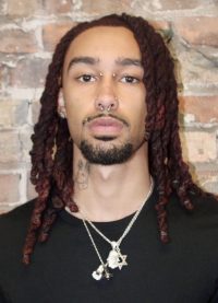 person with long braids looking ahead