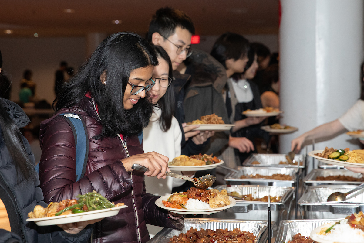 People serving themselves food in a buffet line