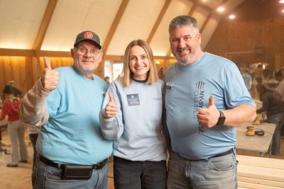 three people giving the thumbs-up sign