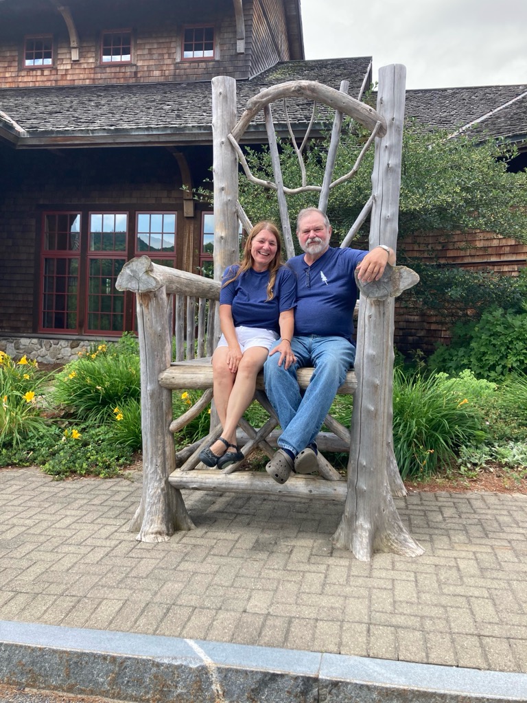 Two people sitting in a very large oversized chair