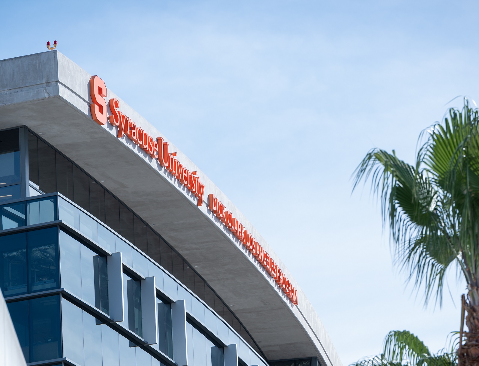 top of building with sign at top that has block S and wording that states Syracuse University Dick Clark Los Angeles program