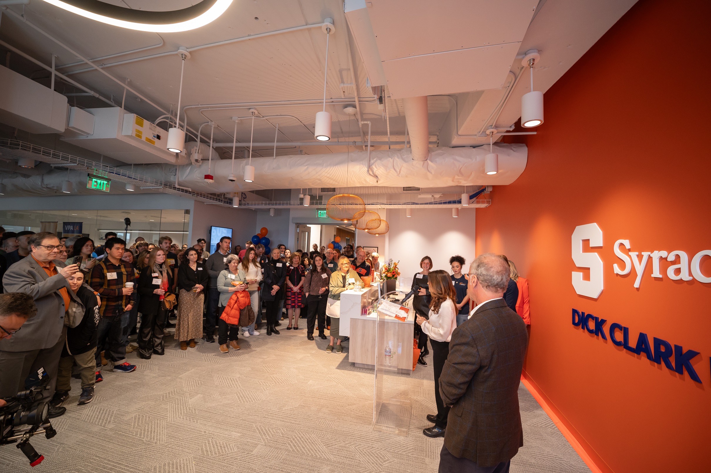person speaking at podium to group of people