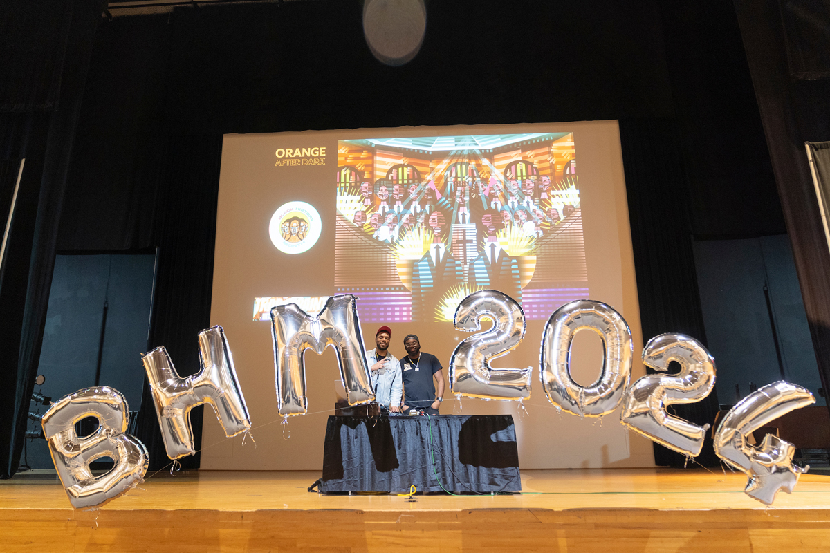 Two students smile for a photo with balloons spelling out BHM 2024
