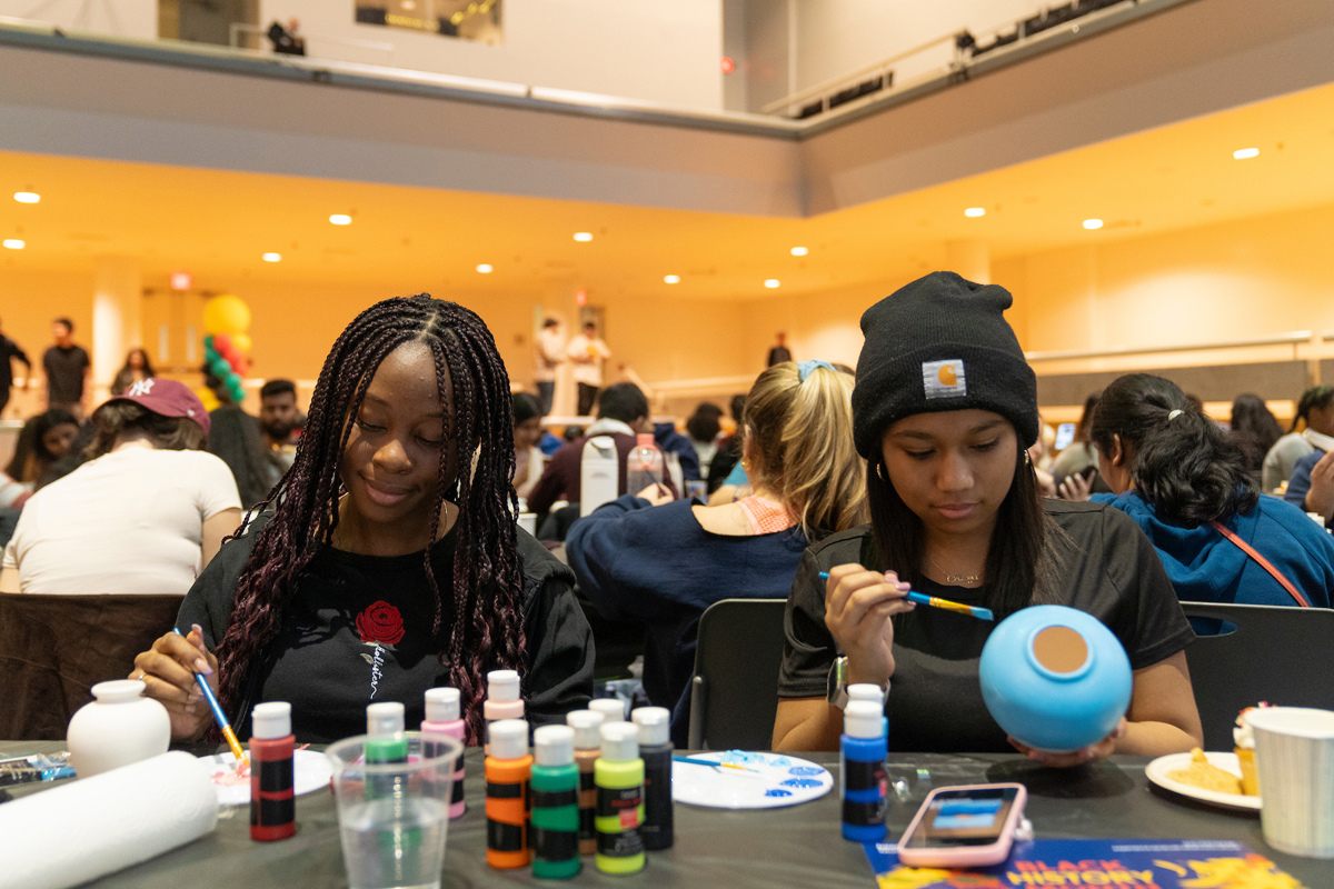Two students paint.