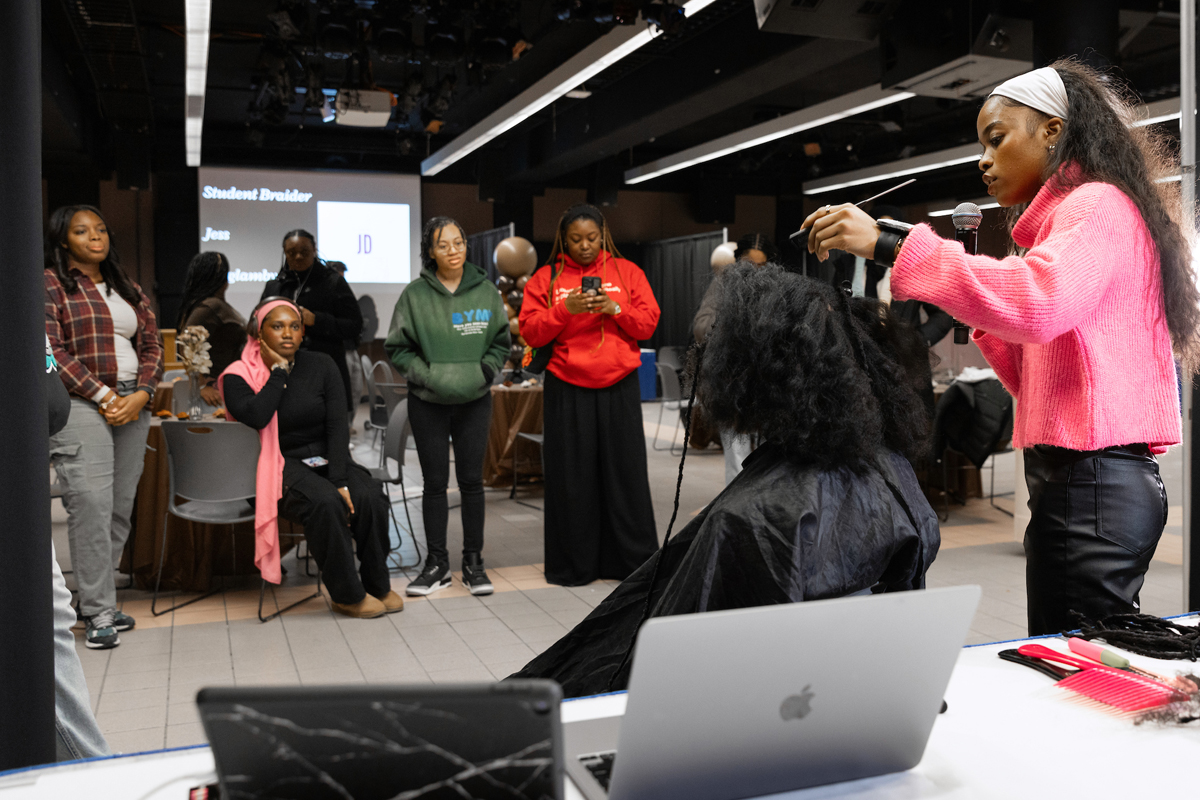 A woman works on a student's hair.