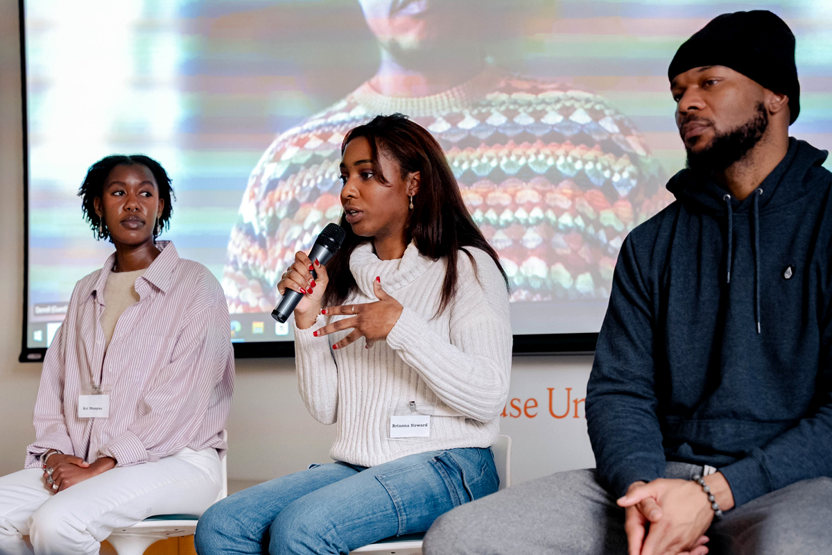 Three presenters address a crowd of students.