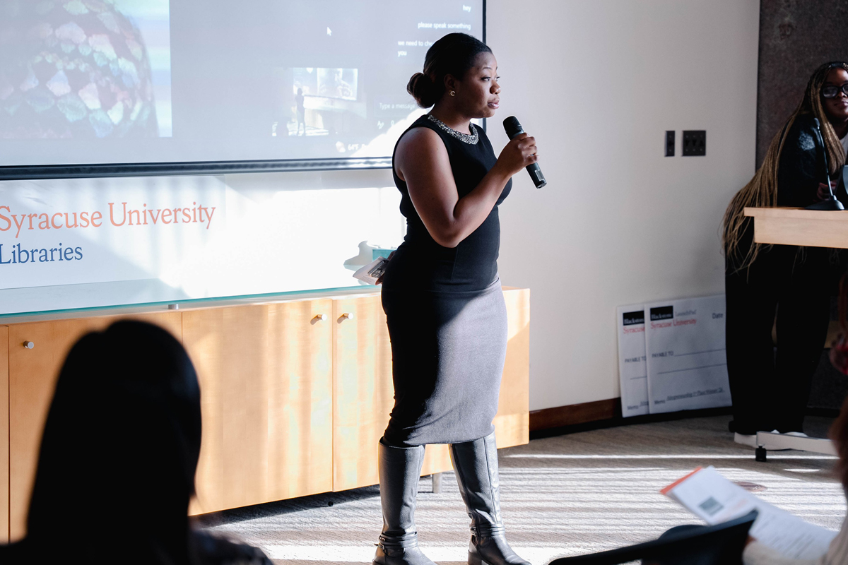 A woman speaks to a room full of students.