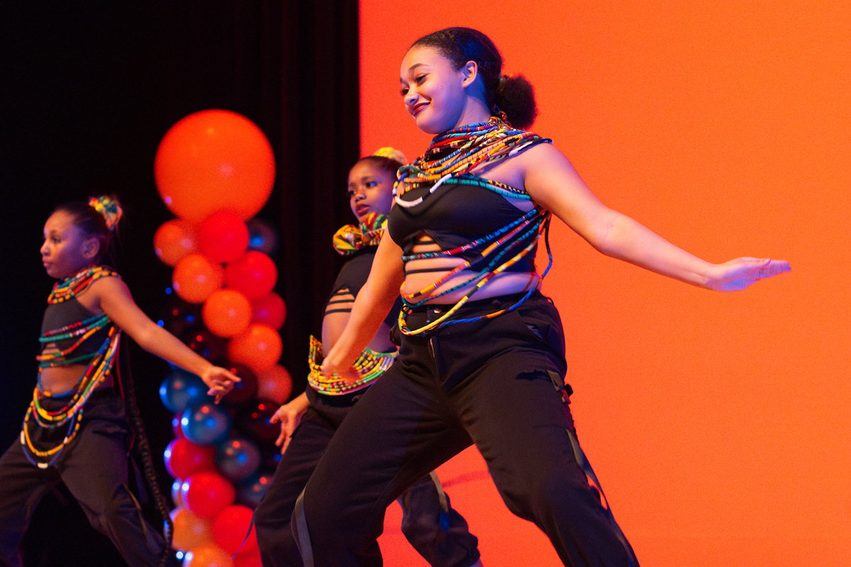 Three student dancers perform.