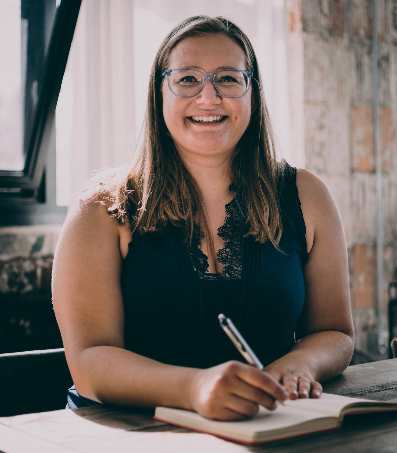 woman with a pen and book writing