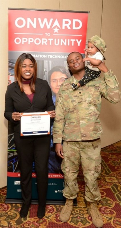 A soldier poses with a woman and a child.