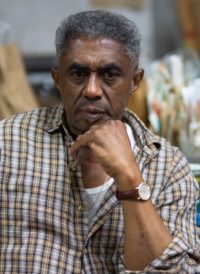 man looking at the camera with bent elbow up to chin