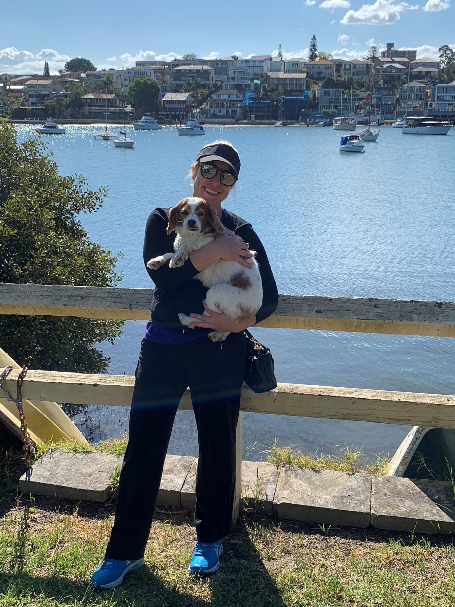 person holding dog with lake in background