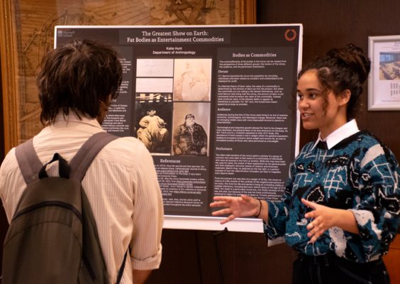Two people engage in conversation about a research project.