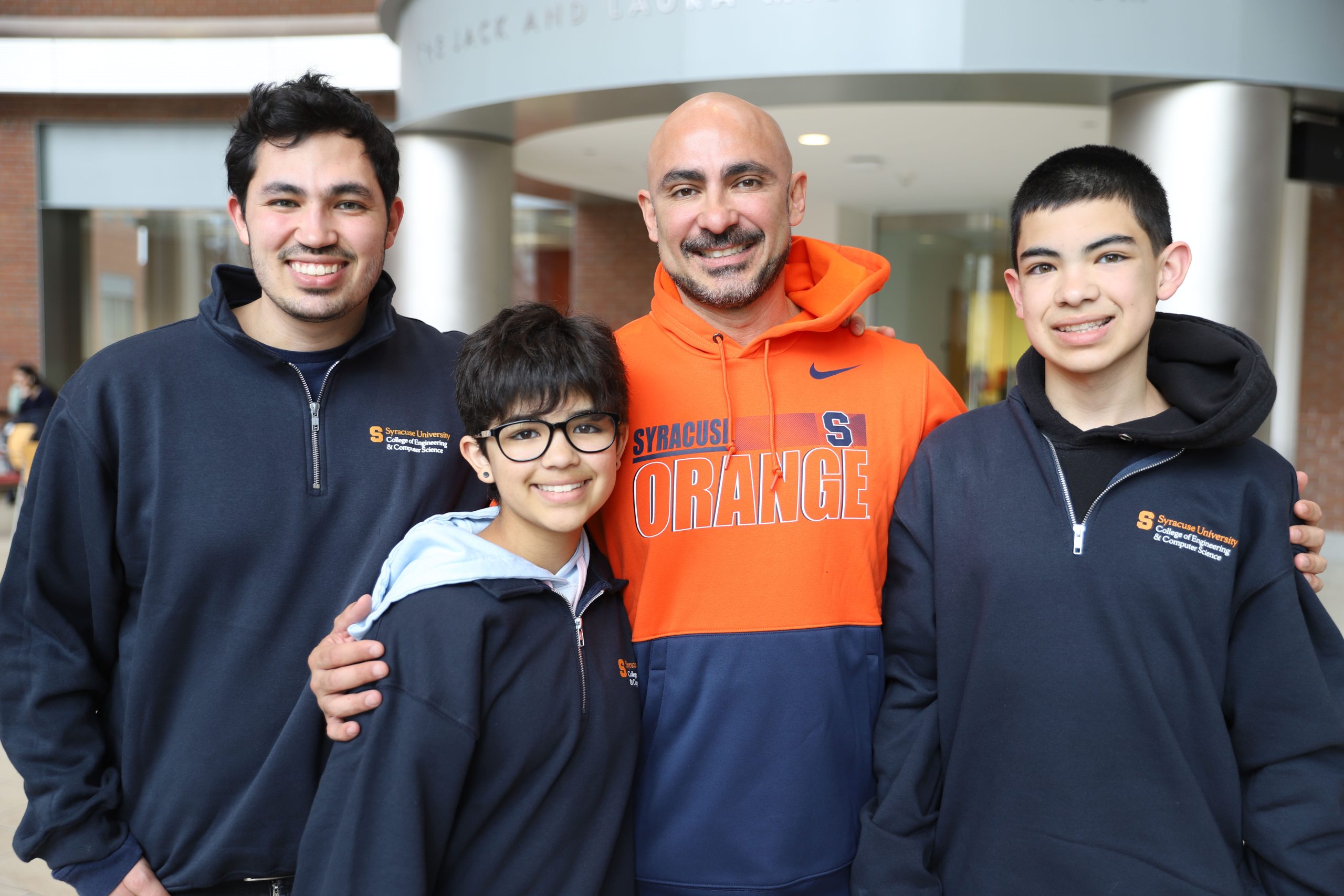 Man standing with his three children.