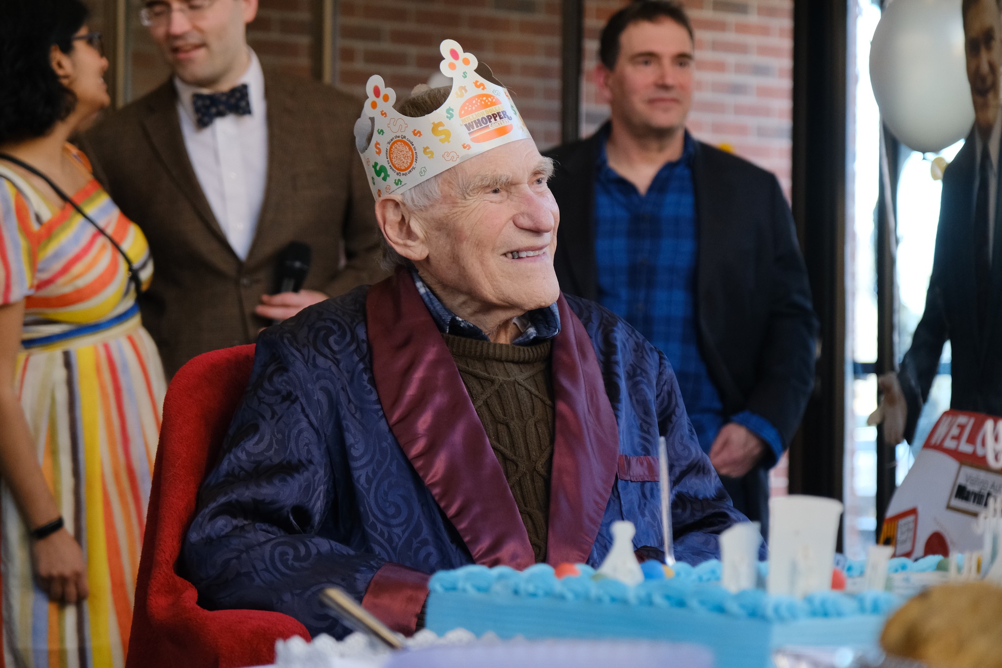 Man wearing a Burger King crown smiling