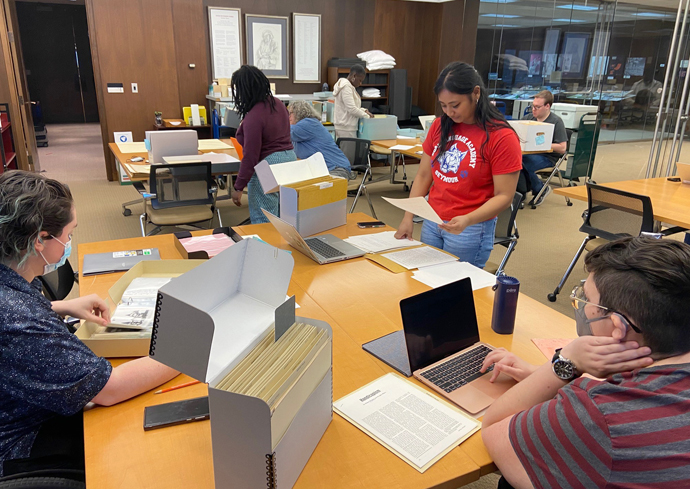 Students examine materials in the library.