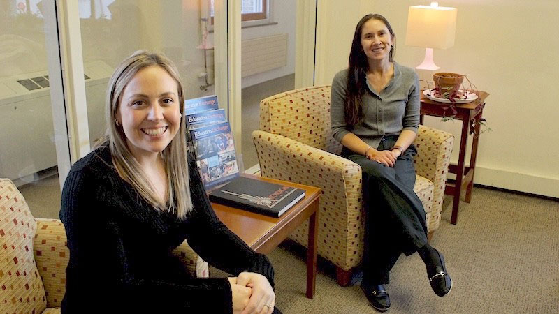 Two people sitting on chairs in an office