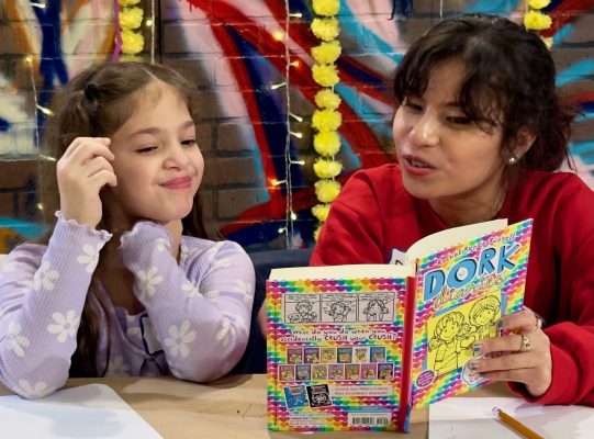 older young woman reading a book to a young girl