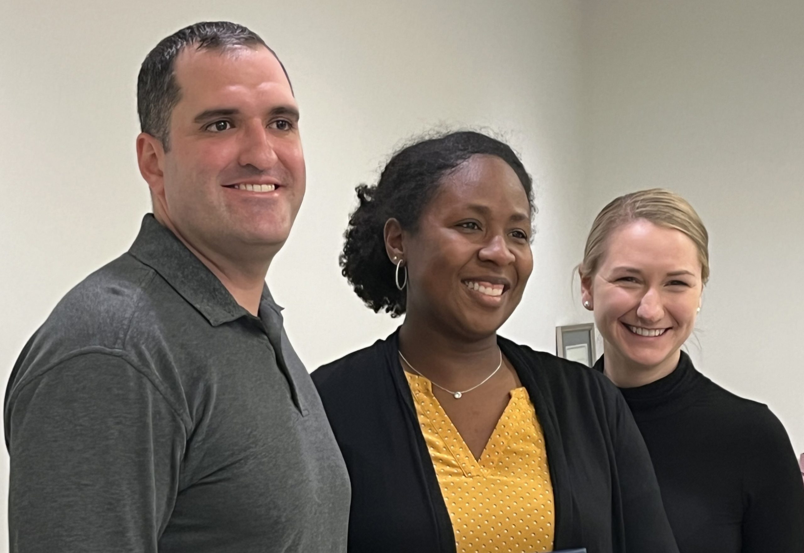Three people standing together smiling