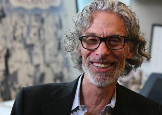 A man smiles while posing for a headshot.