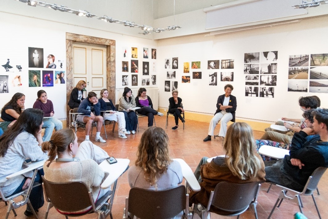students in a circle listen to a speaker