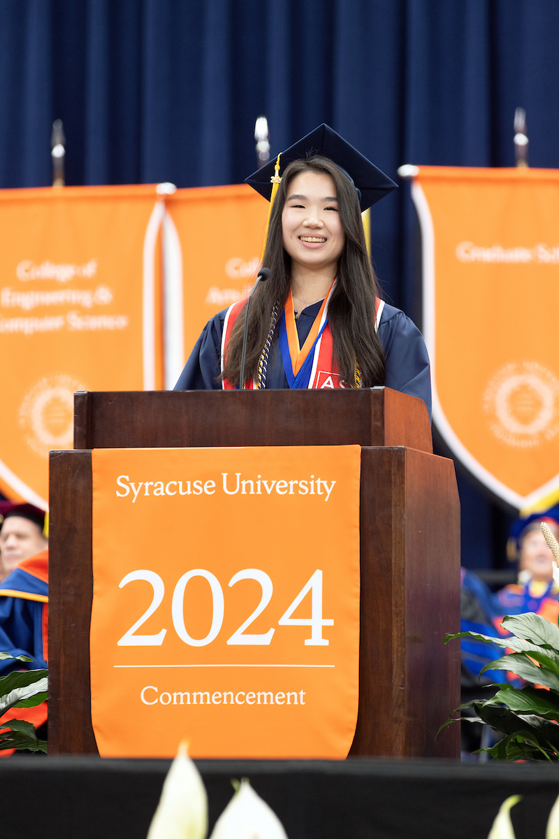 Student standing at the podium at Commencement speaking