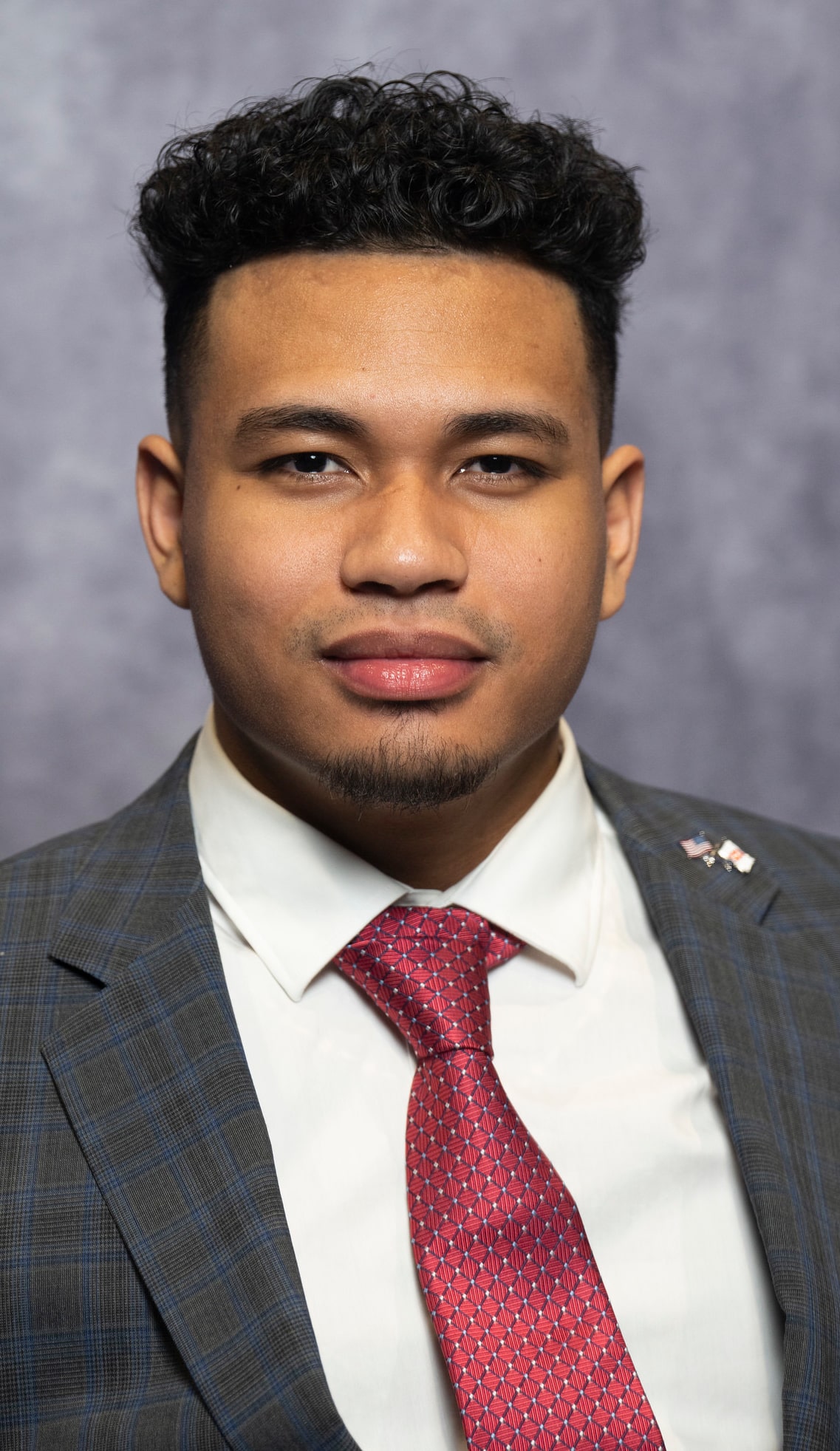 A man poses for a headshot while standing indoors.