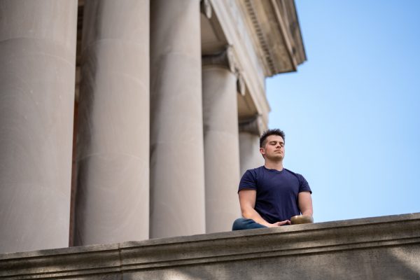 Student meditating outside Hendricks Chapel