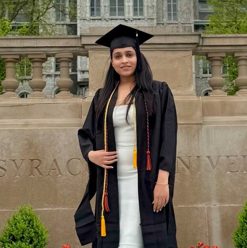 person standing in front of Hall of Languages wearing a graduation cap and gown