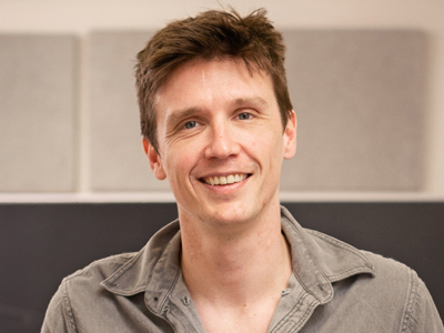 A man smiles while posing for a headshot