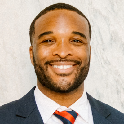 A man smiles while posing for a headshot.