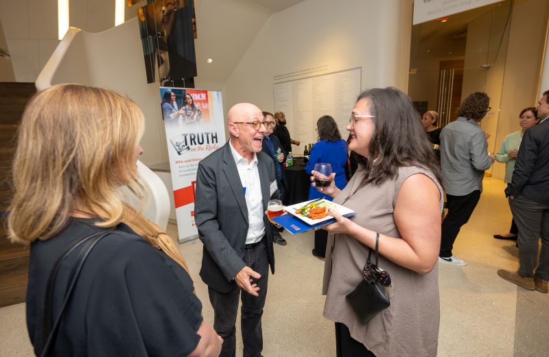 women and man speaking at a reception