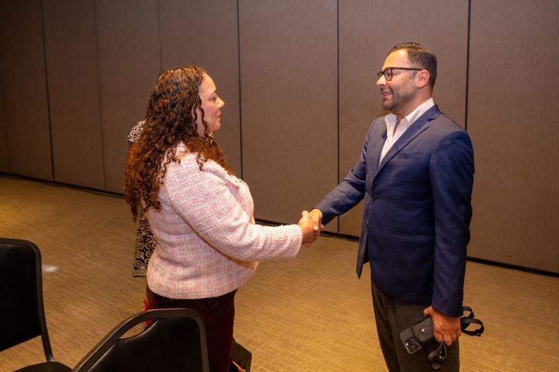 woman and man shaking hands in a room