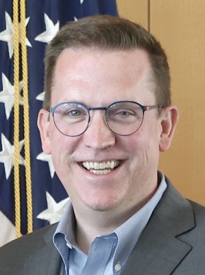 A man smiles for a headshot.