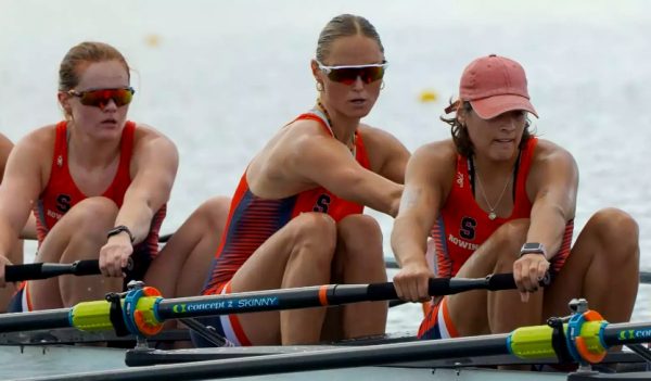 Three women row in a competition.