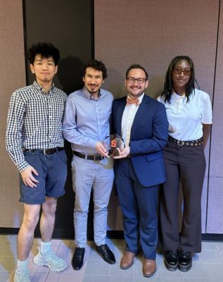 Students and staff pose for a photo during an awards ceremony on campus.