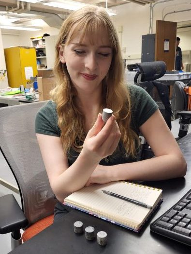 young woman looking at cylinder-shaped items