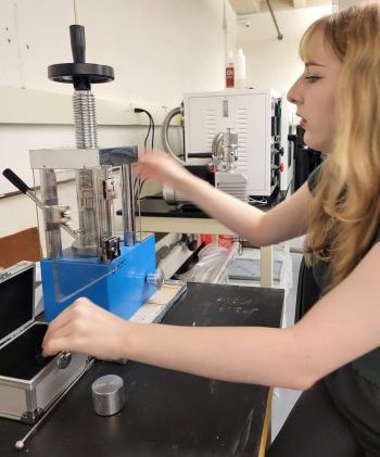 young woman operating a machine in a lab