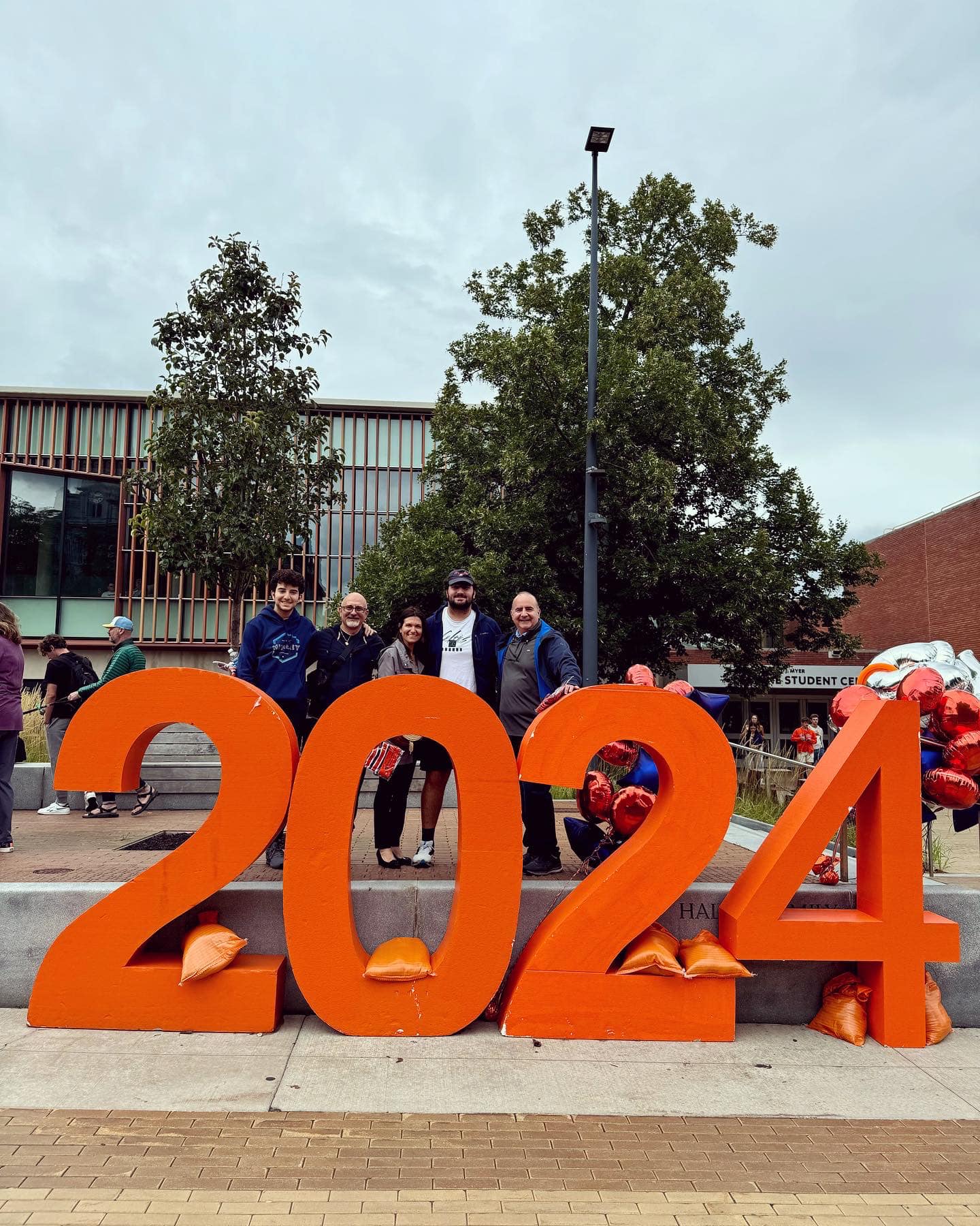 Five people standing behind a large 2024 sign in orange in front of the Schine.