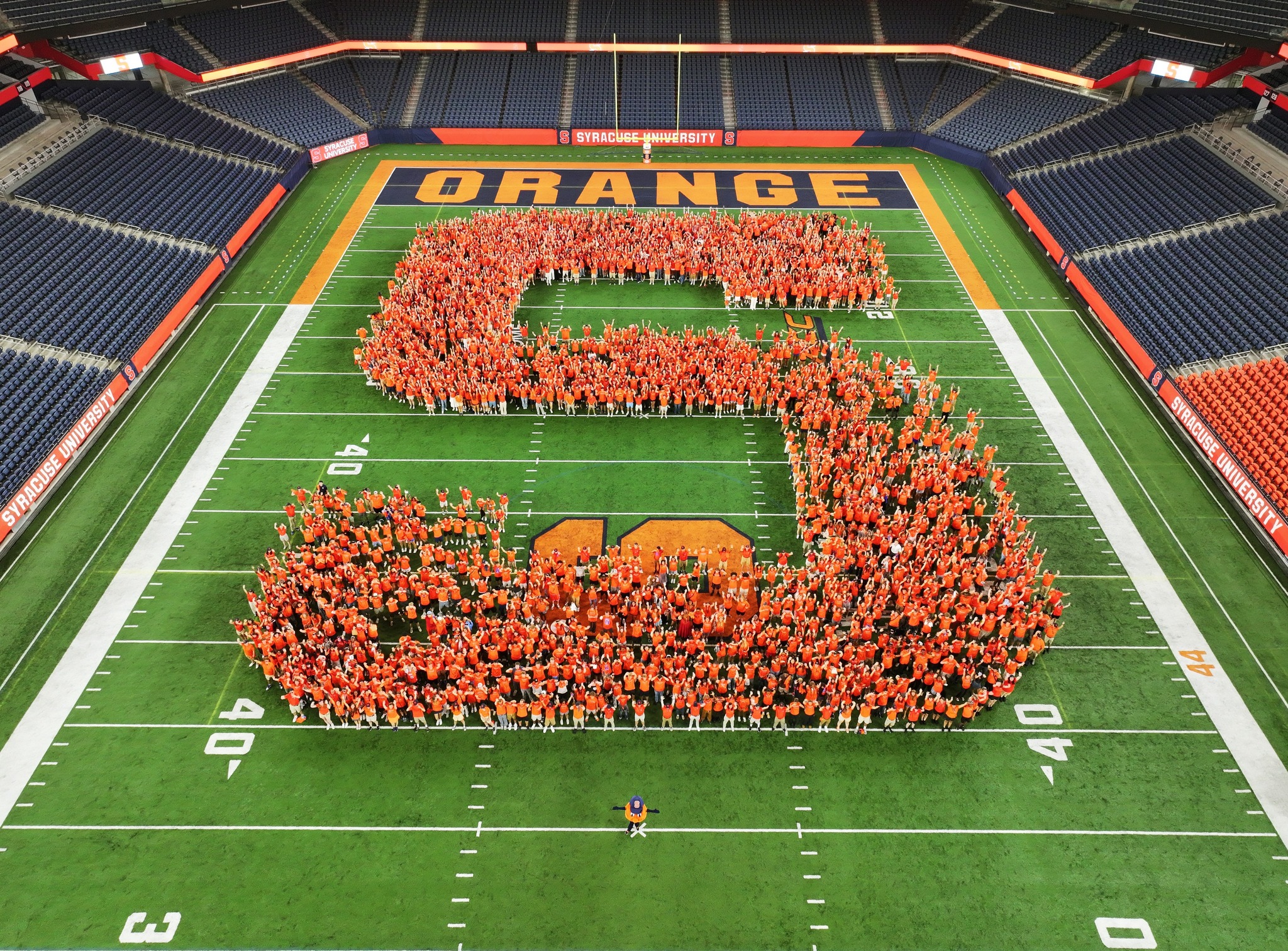 Students standing together to form the shape S on the field 