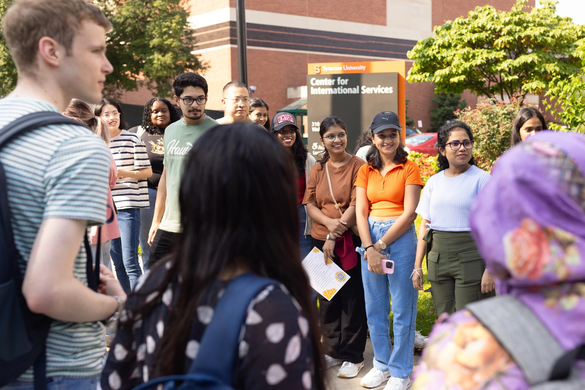 Group of people standing in a circle outside.
