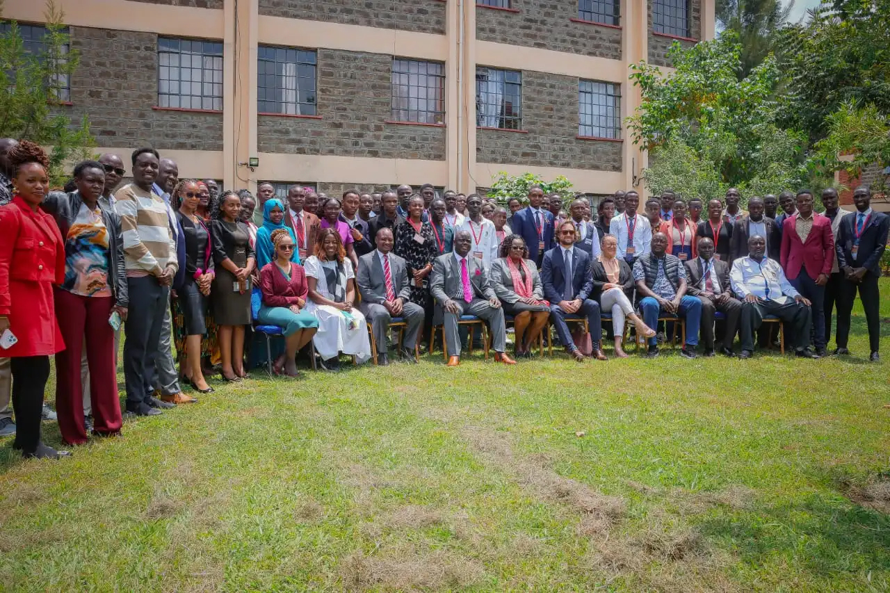 Large group of people standing together in the lawn in front of a building