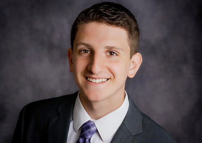 A man smiles while posing for a headshot.