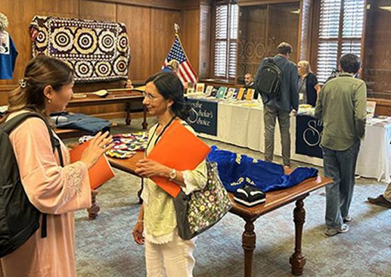 A student speaks with an alumna in the library during a conference.