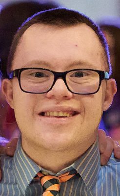 A student smiles while posing for a headshot