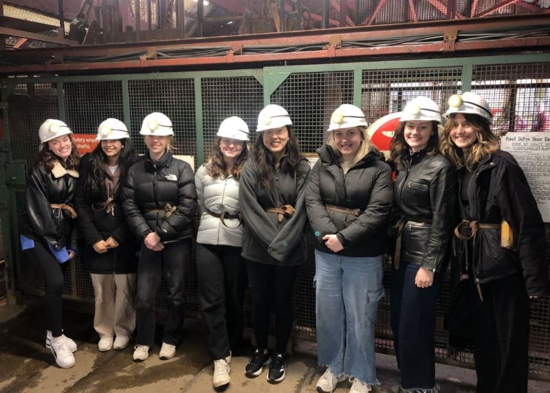 group of young students in hardhats are shown during a tour of a coal mine