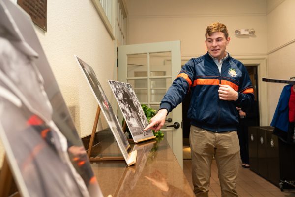 Cameron MacPherson looks at photos of his grandfather, Coach Mac,